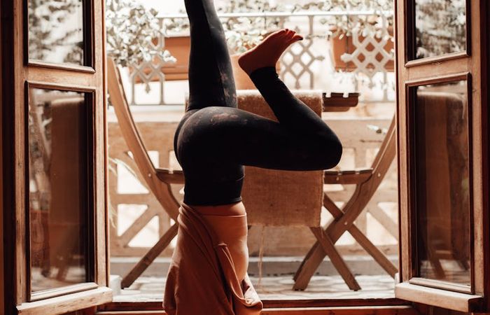 Person doing a balancing yoga pose in a bright, minimalist room.